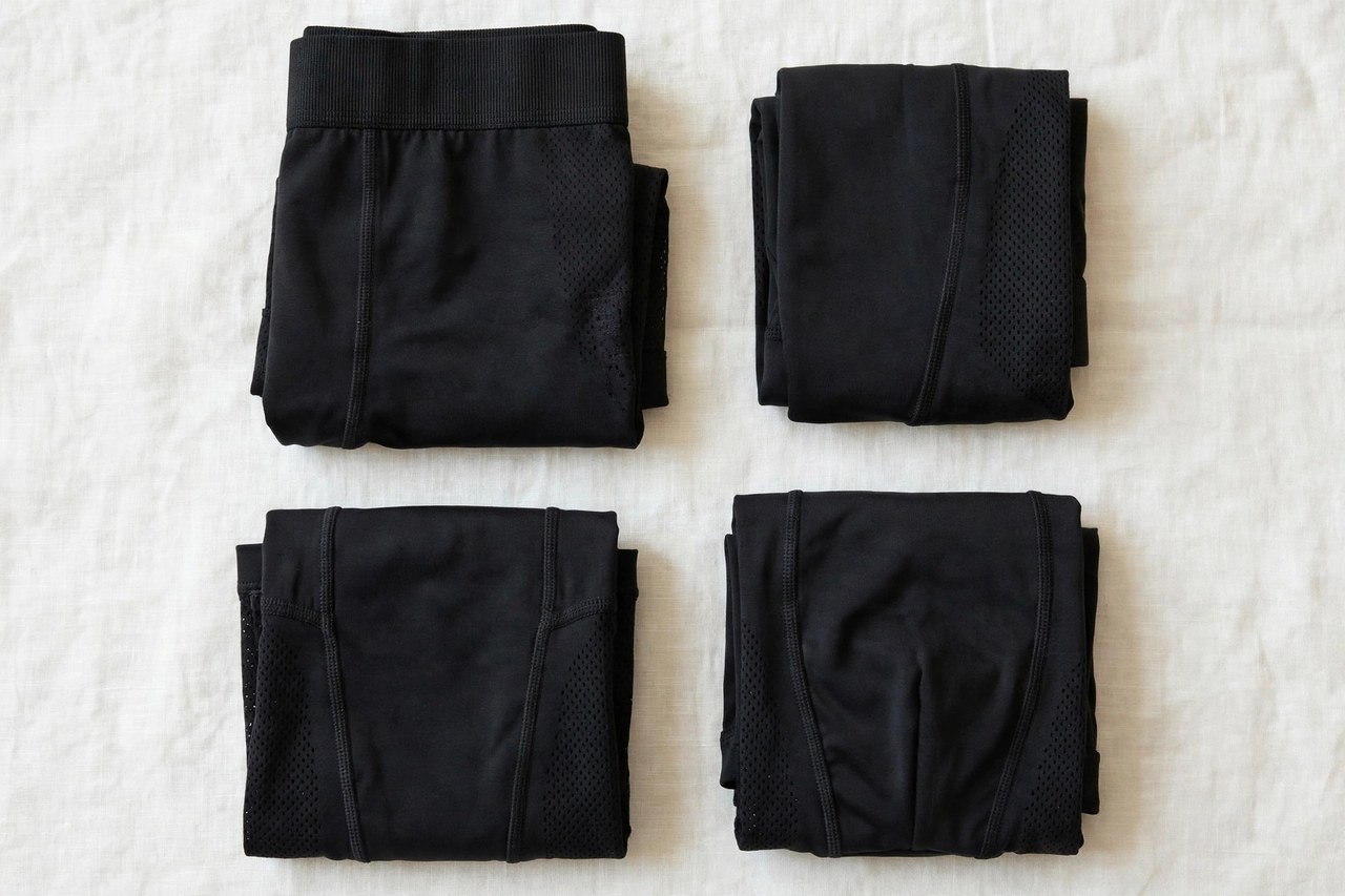 A flat lay of folded men's supportive athletic underwear in black, product photography with no people and no mannequins