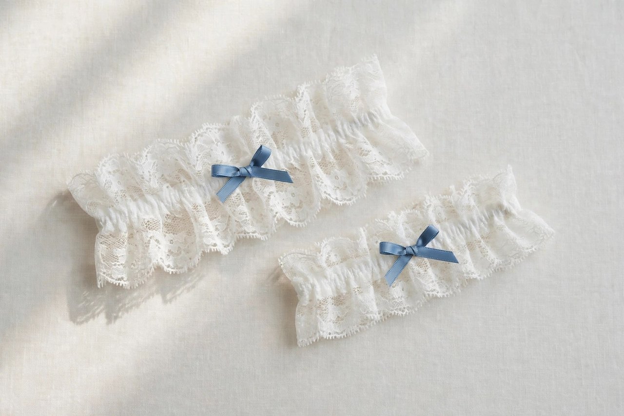 White lace wedding garter with a small blue ribbon detail on a light background