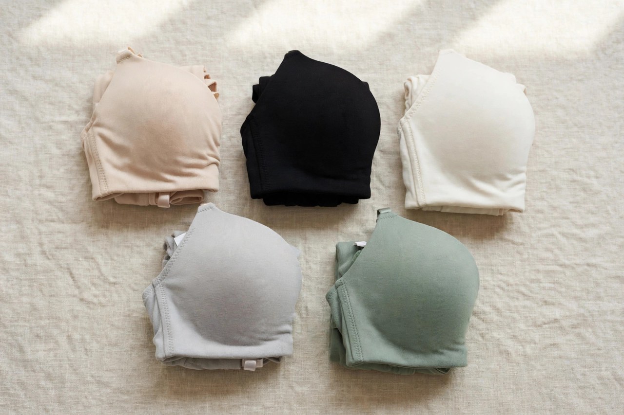 Neatly folded plain women's seamless underwire bras with smooth cups on a clean background