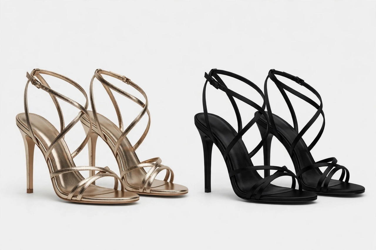 Elegant heeled sandals in gold and silver metallic finishes with slender straps arranged on a smooth surface.