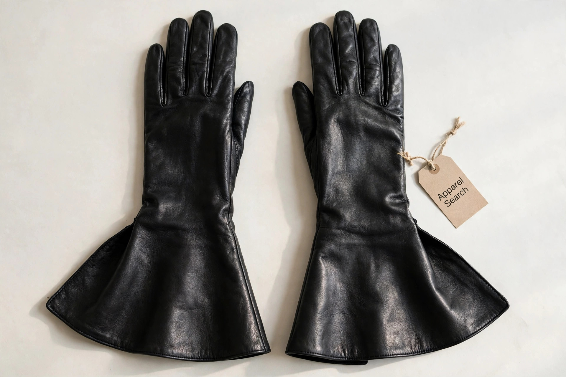 Women's long black leather gauntlet gloves with wide flared cuffs lying flat, product photography with no people