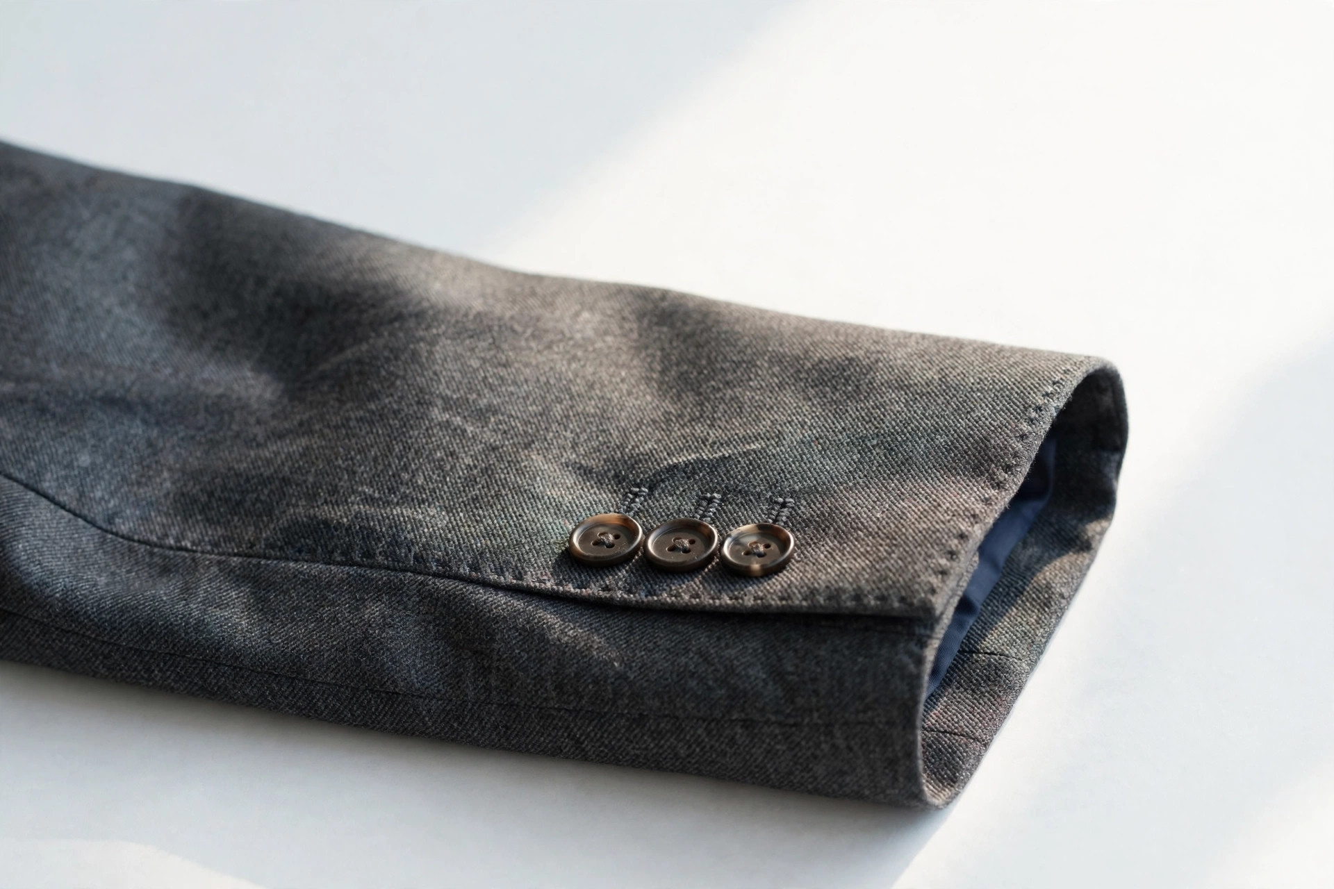 Close-up of a bracelet-length sleeve ending just above the wrist on a tailored jacket