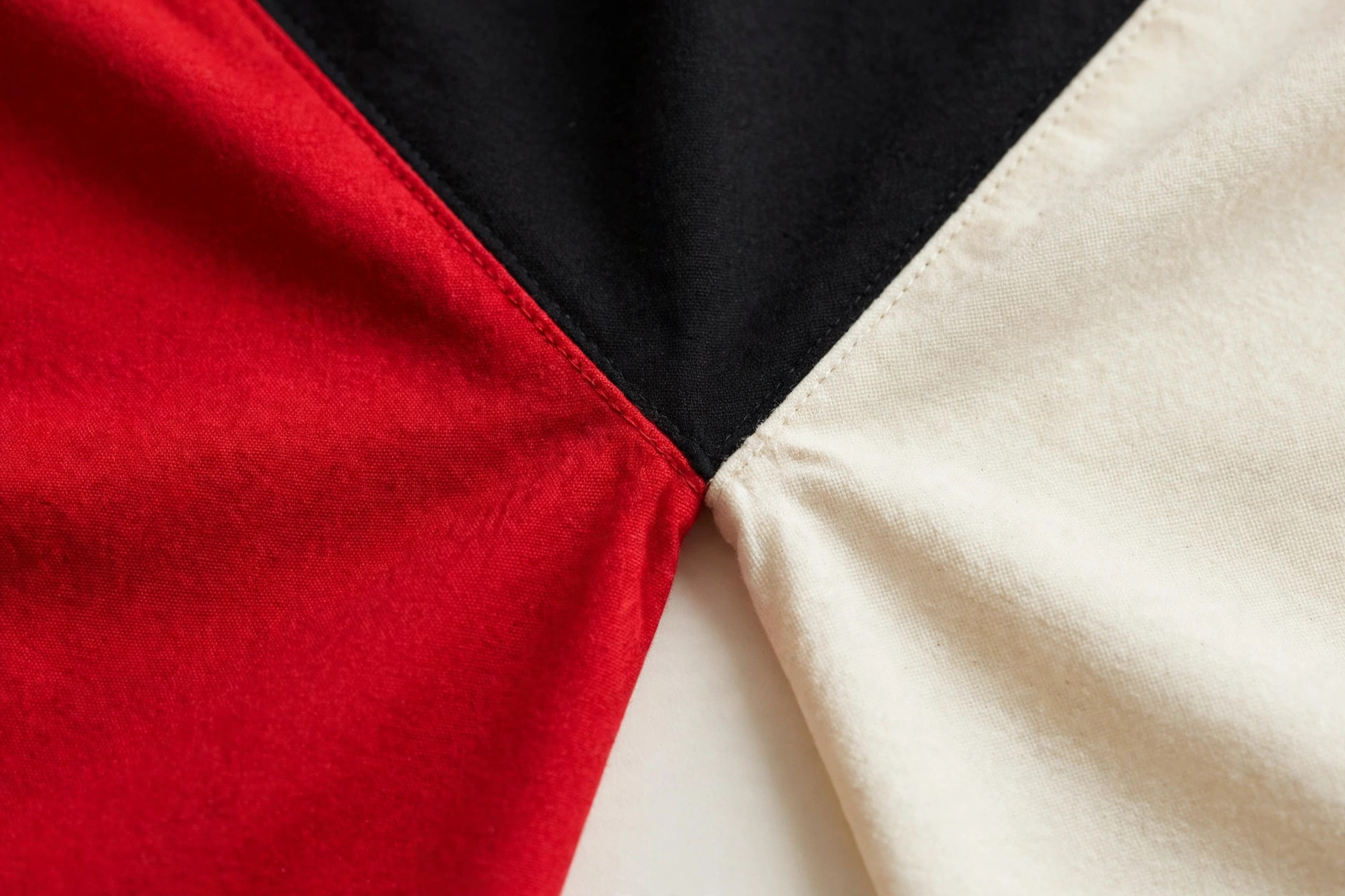 Color-block garment fabric panels in bold red, black and cream solid sections