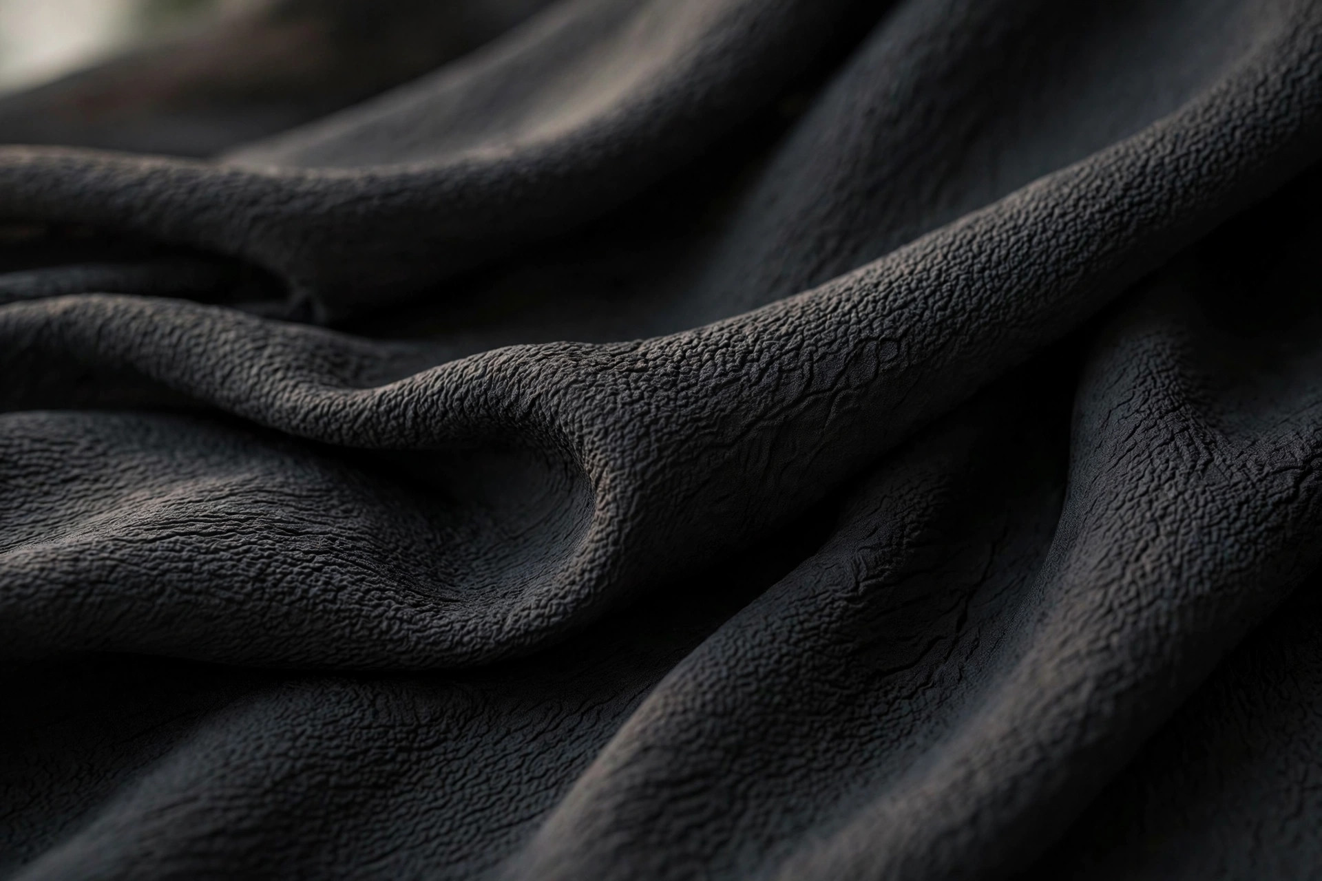Black silk crepe fabric with a pebbled, crinkled texture