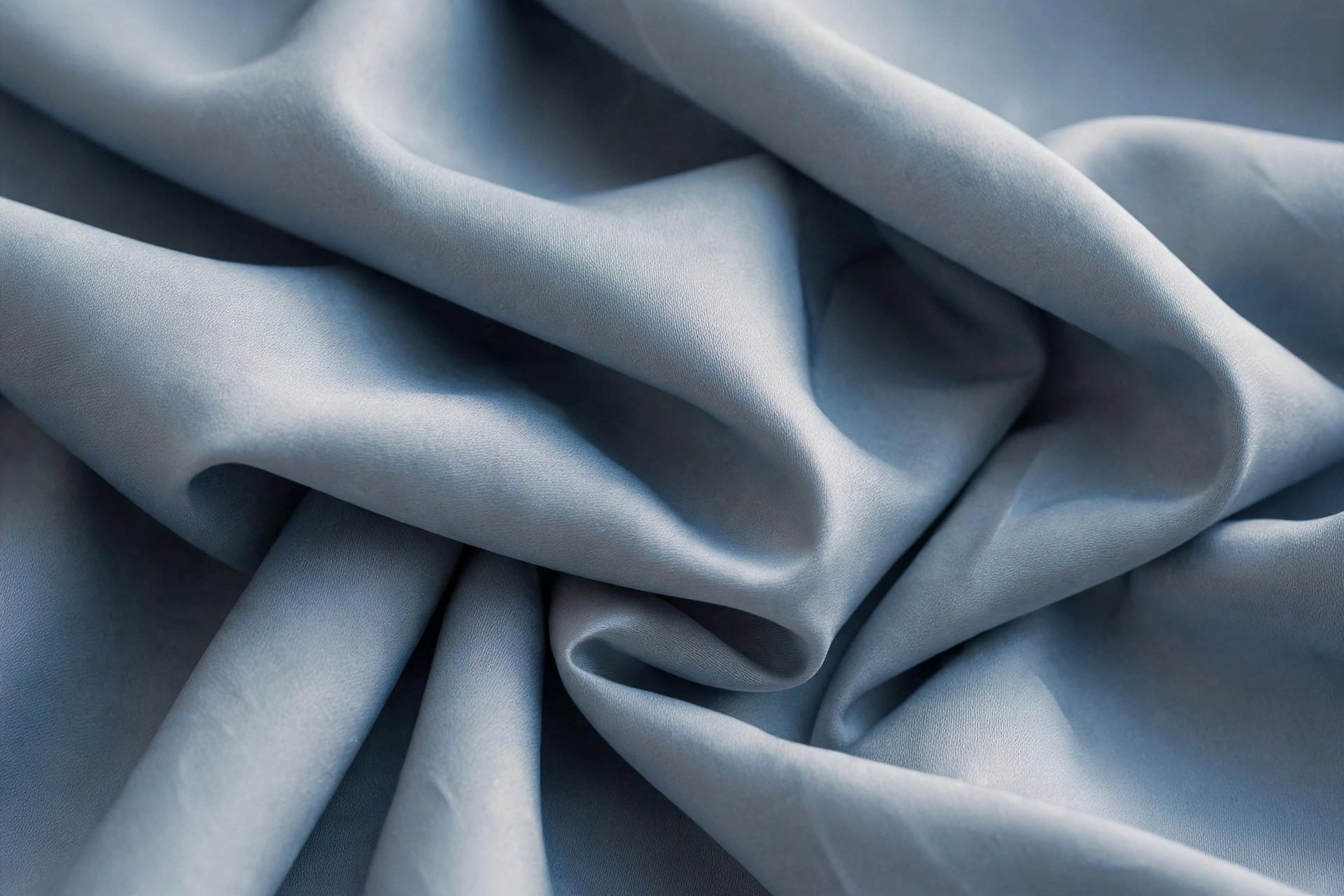 Smooth polyester fabric with a subtle sheen, folded in soft blue-grey tones