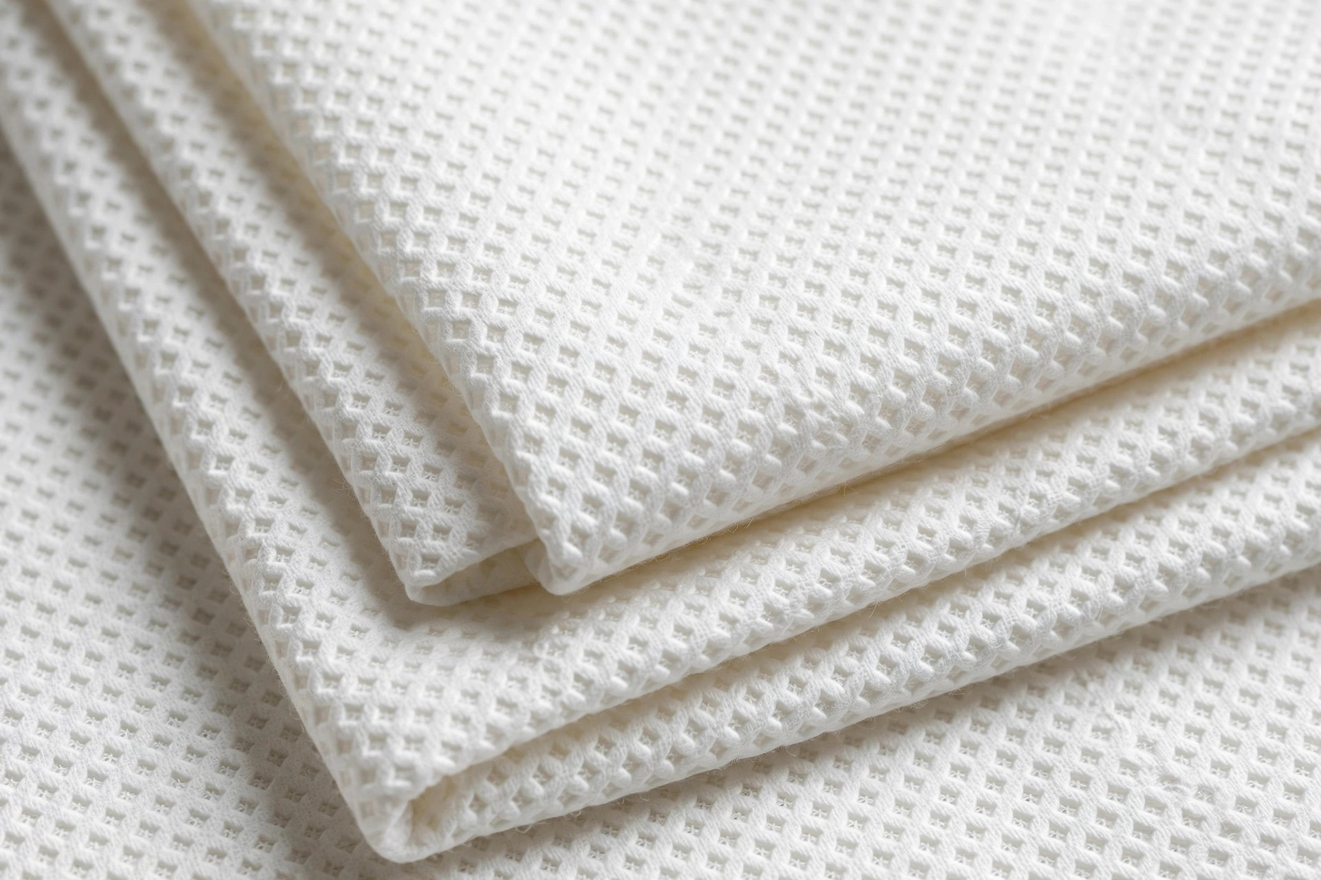 White cotton diaper cloth with a small diamond birdseye weave pattern, folded