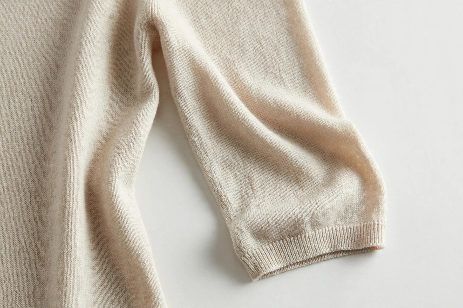Close-up of an elbow-length sleeve ending at the elbow on a knit dress