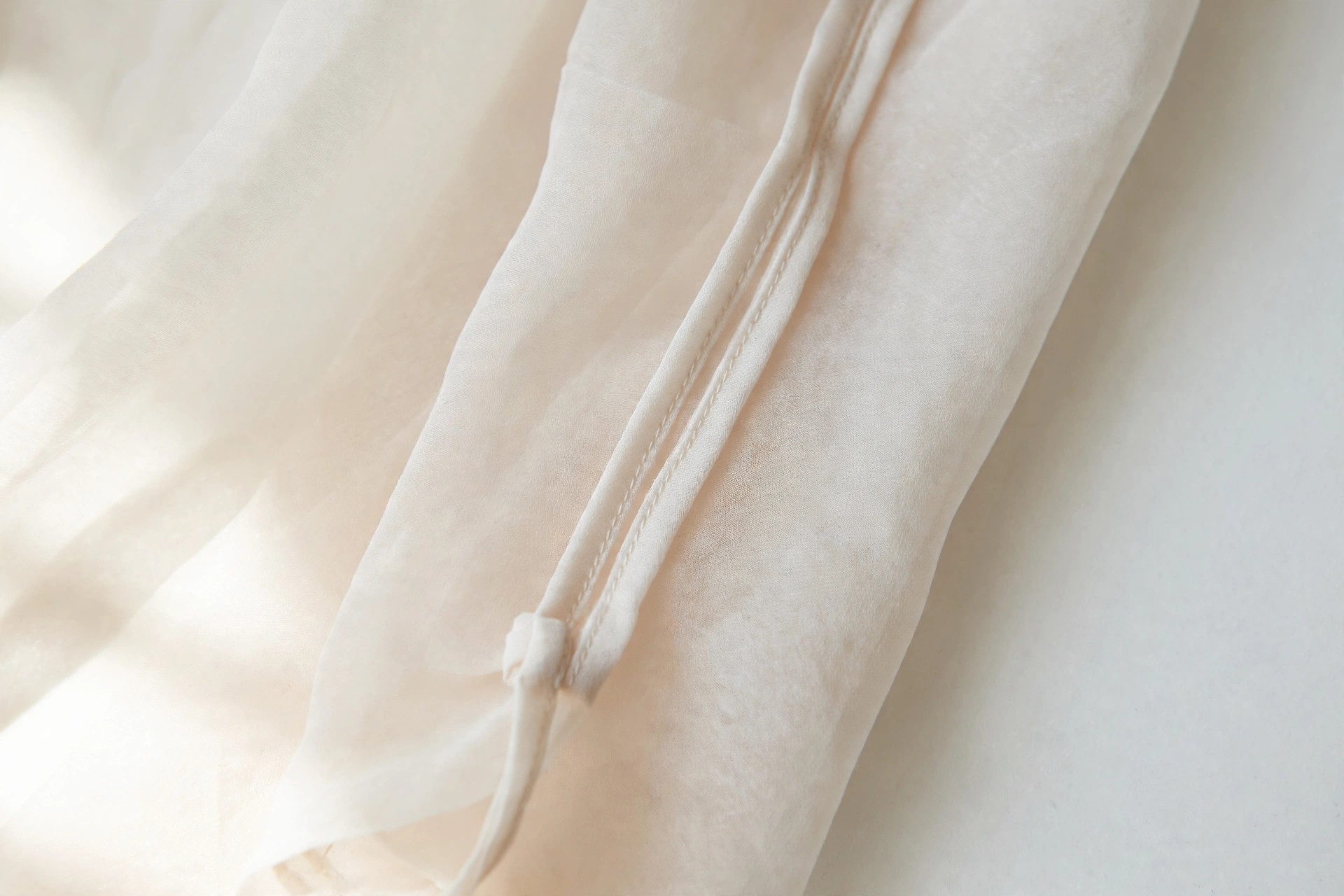 Close-up of a neat French seam inside a sheer blouse