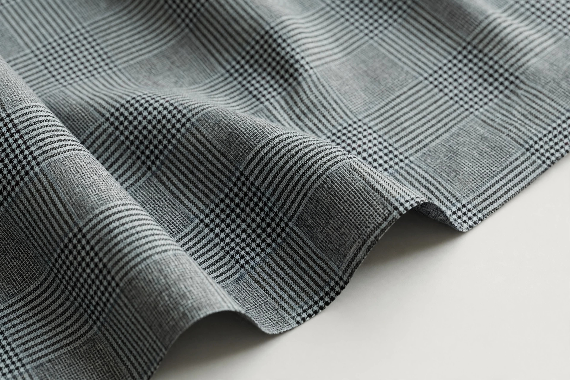 Glen check suiting fabric with muted small and large broken checks in grey and black