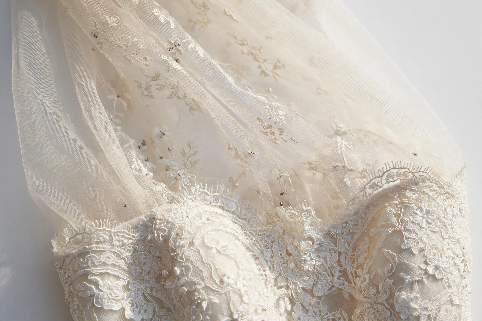 Close-up of an illusion neckline with sheer tulle panel above a lace bodice on a formal gown