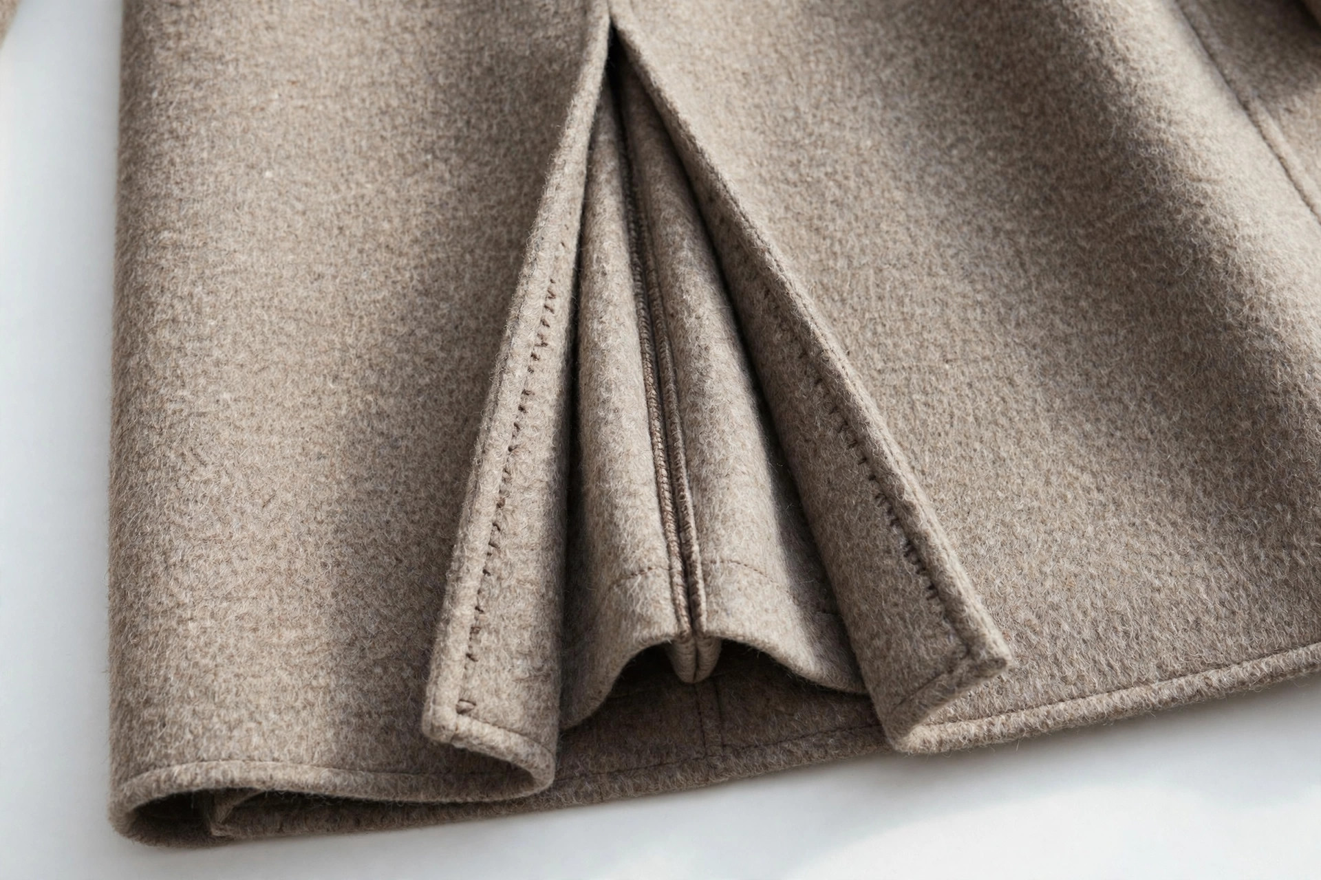 Close-up of an inverted pleat at the back vent of a wool coat
