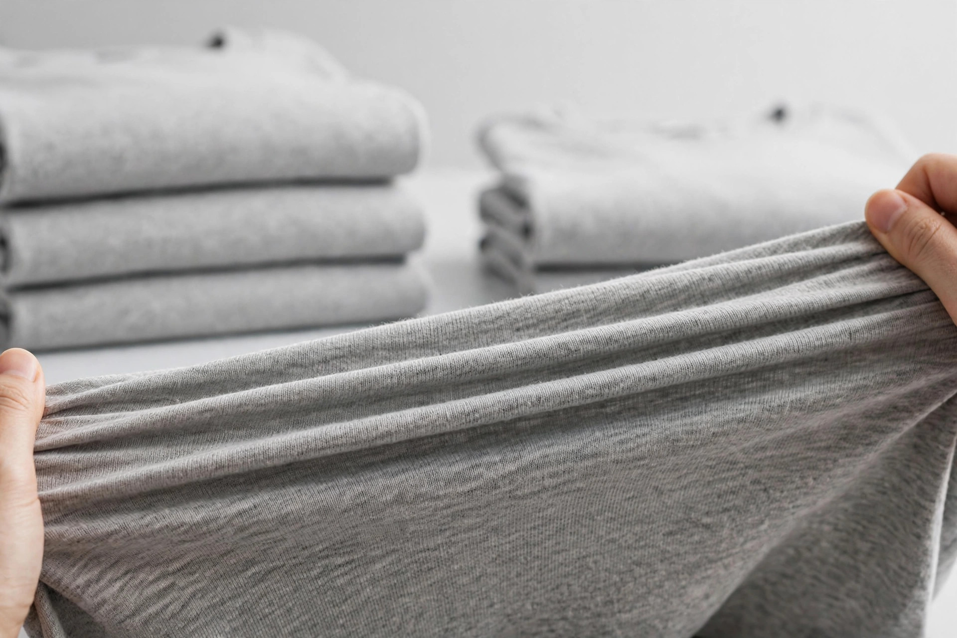 Soft heather-gray jersey knit fabric folded to show its smooth stretchy surface