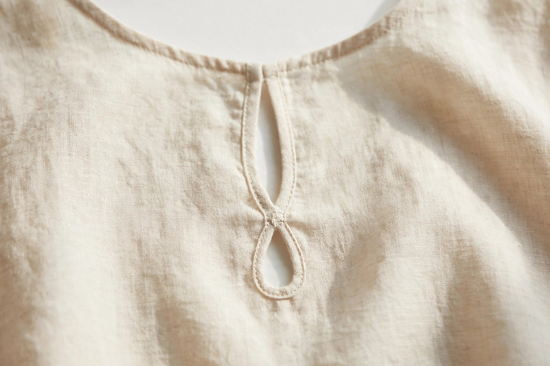 Close-up of a keyhole neckline with a small teardrop cut-out on a blouse