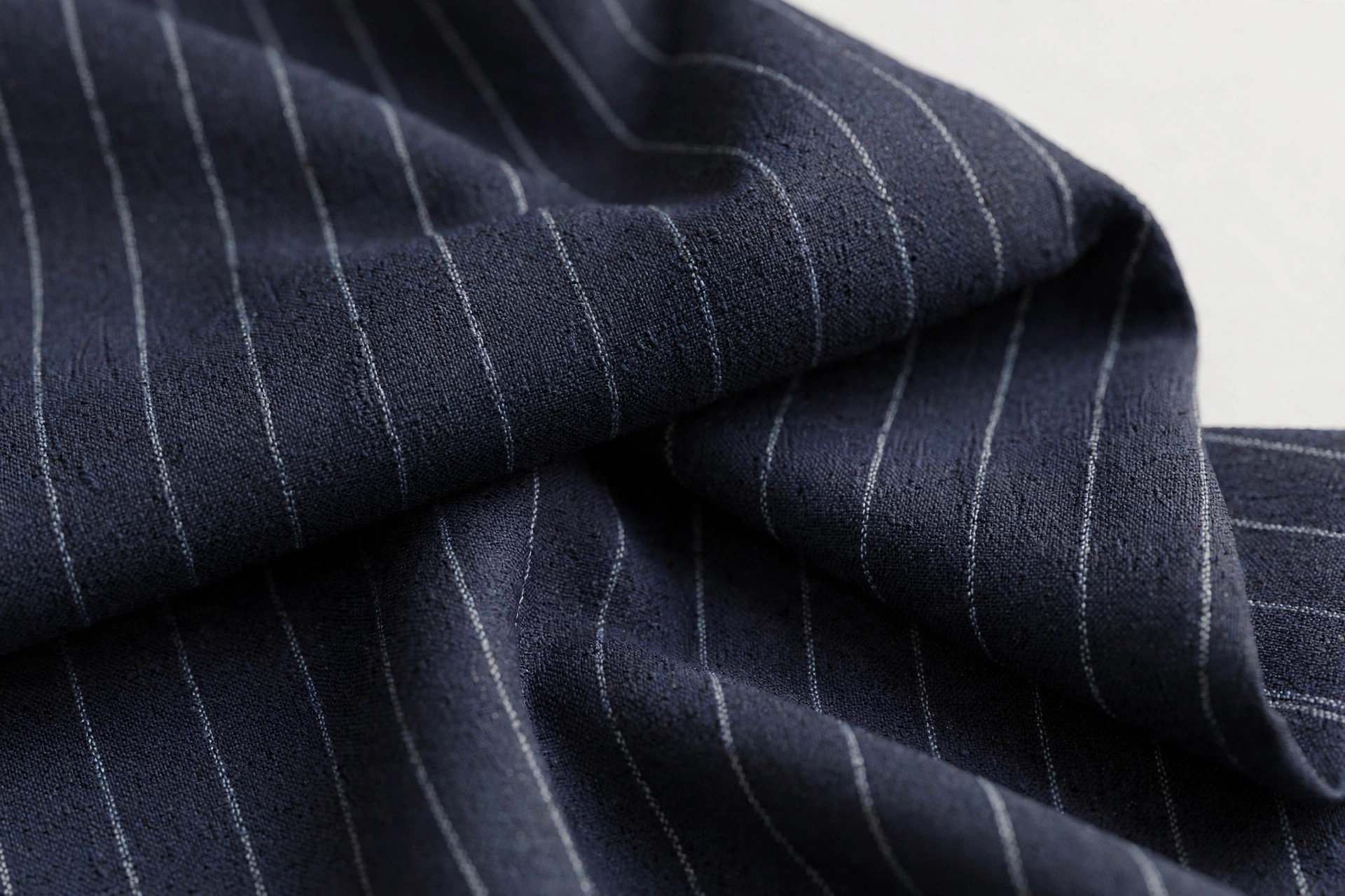 Dark navy pinstripe suiting fabric with fine single thread stripes