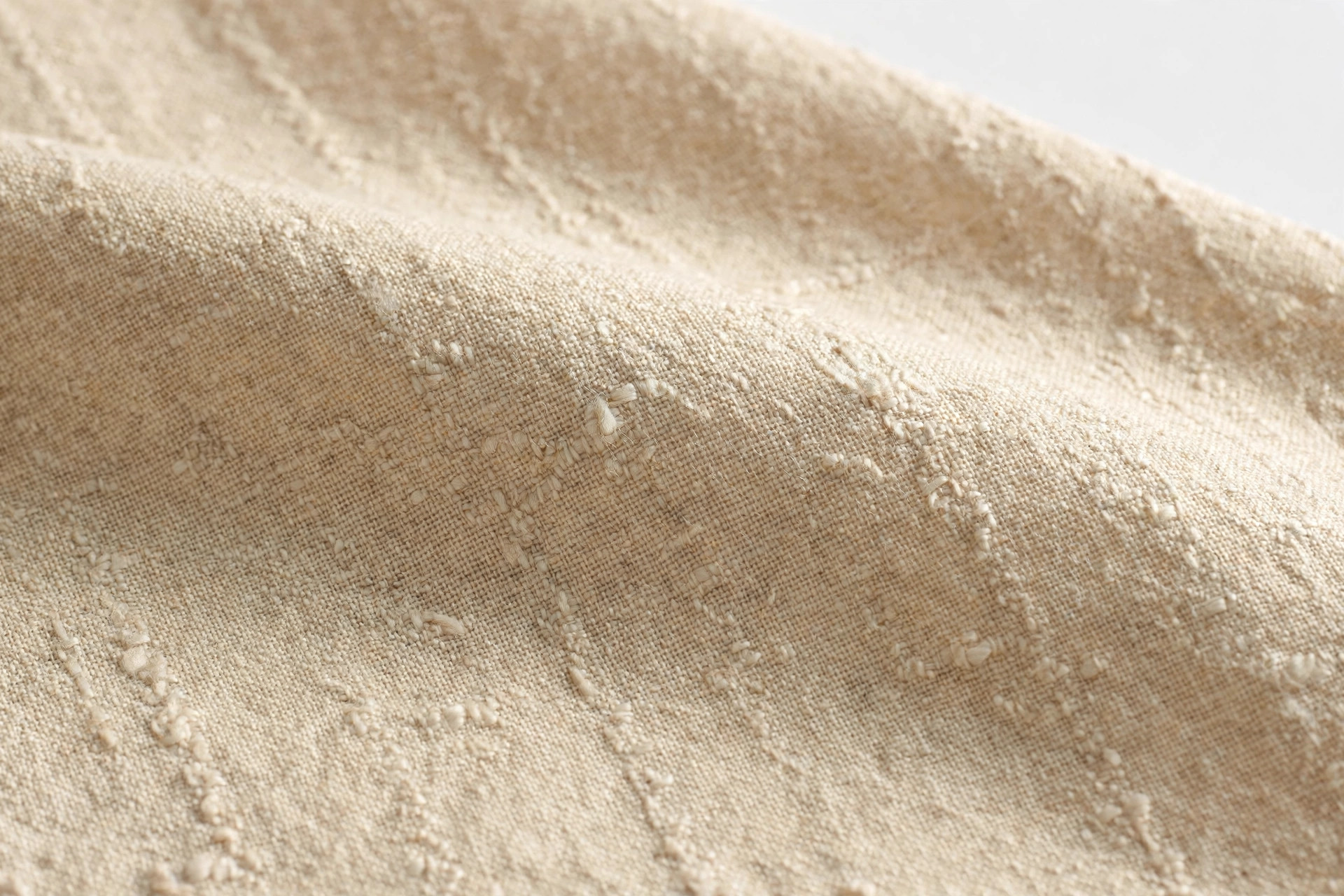 Natural ecru shantung fabric close-up showing slubbed plain weave texture