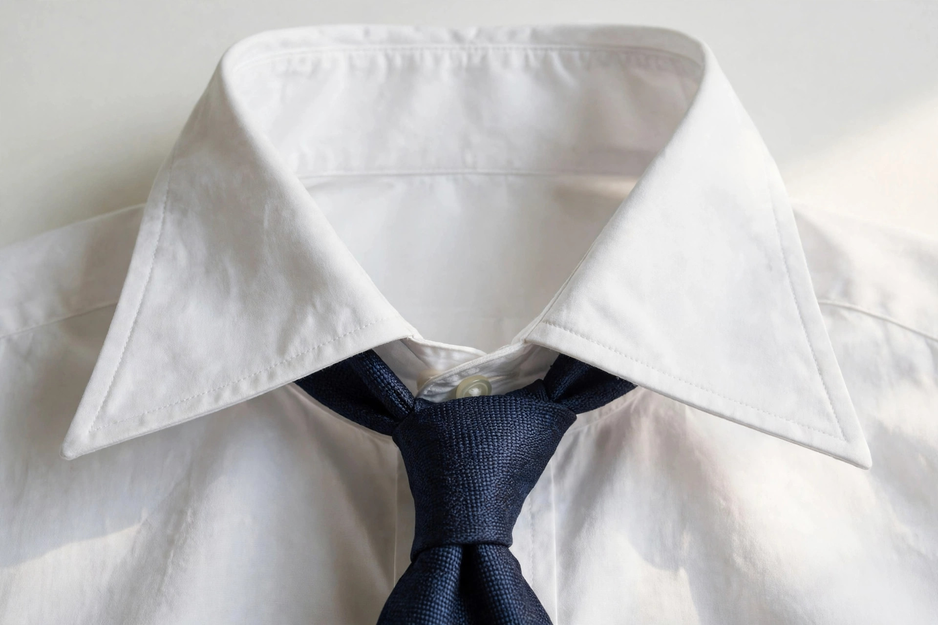 Close-up of a spread collar with wide-apart points on a men's dress shirt with tie