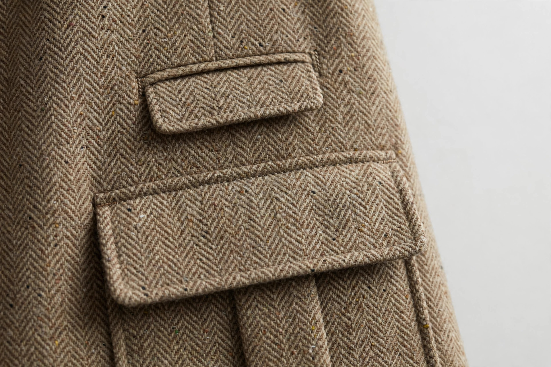 Close-up of a small ticket pocket above the flap pocket of a tweed jacket