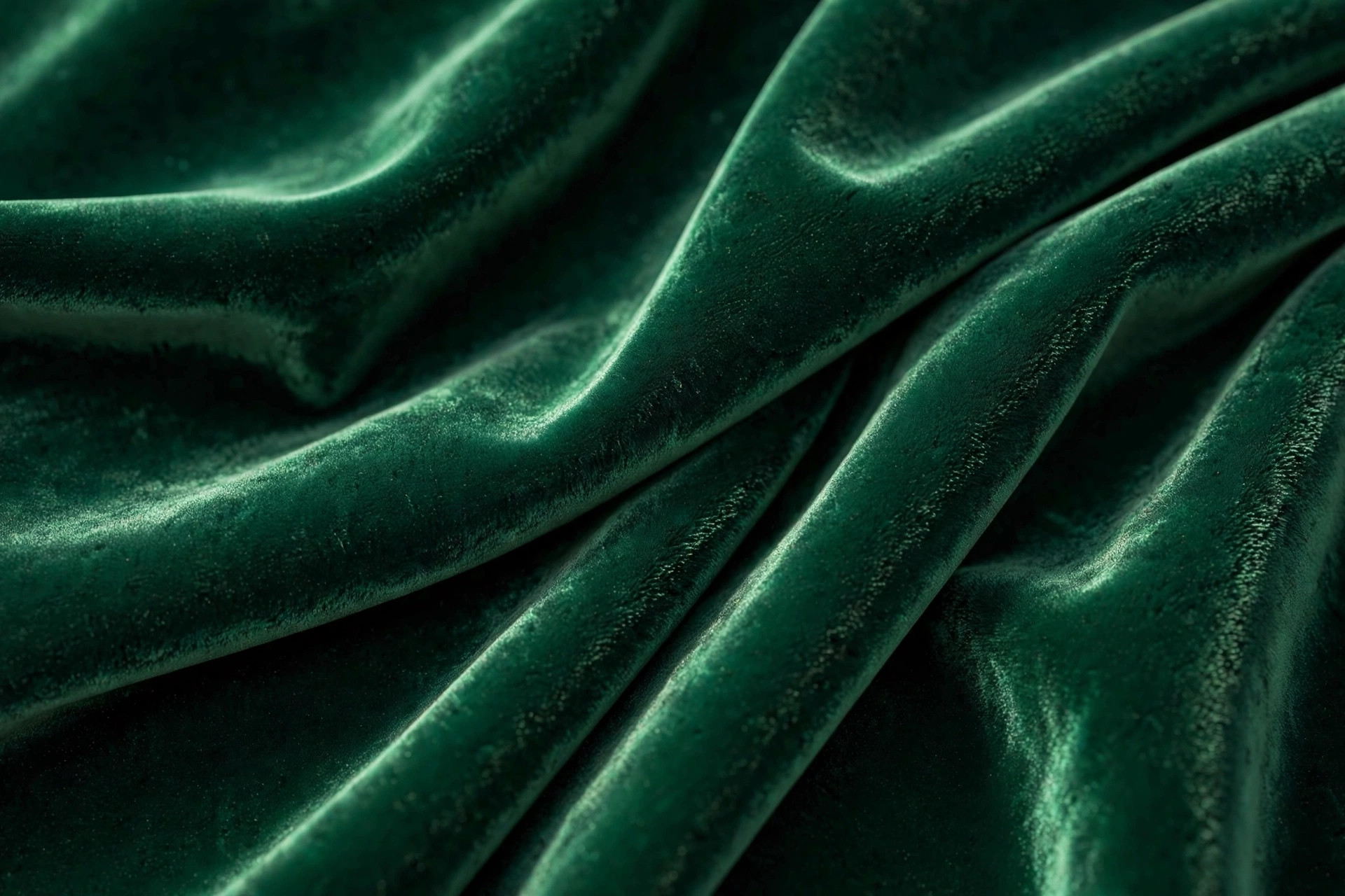 Deep emerald velvet fabric with light catching the soft raised pile