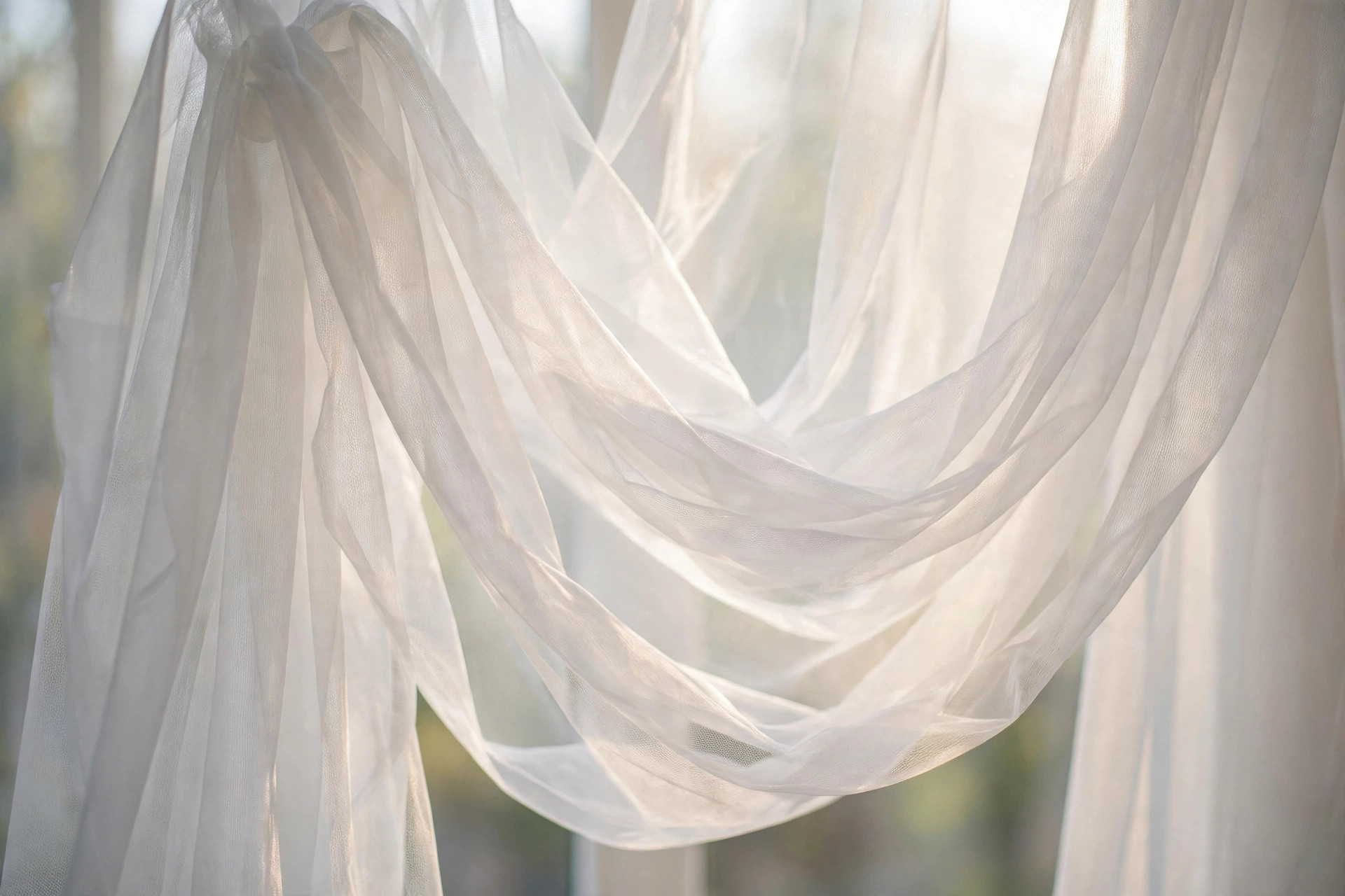 Sheer white voile curtain fabric glowing in soft window light