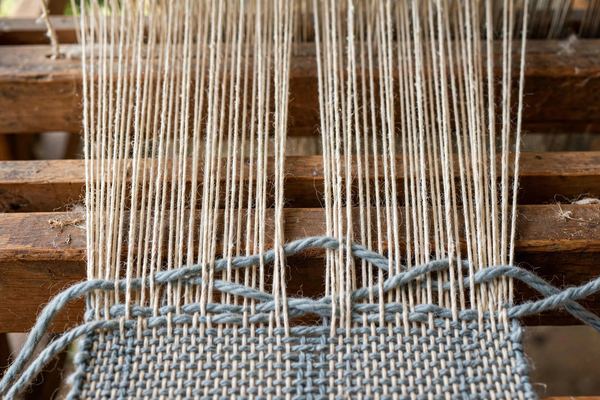 Warp and weft threads interlacing on a loom