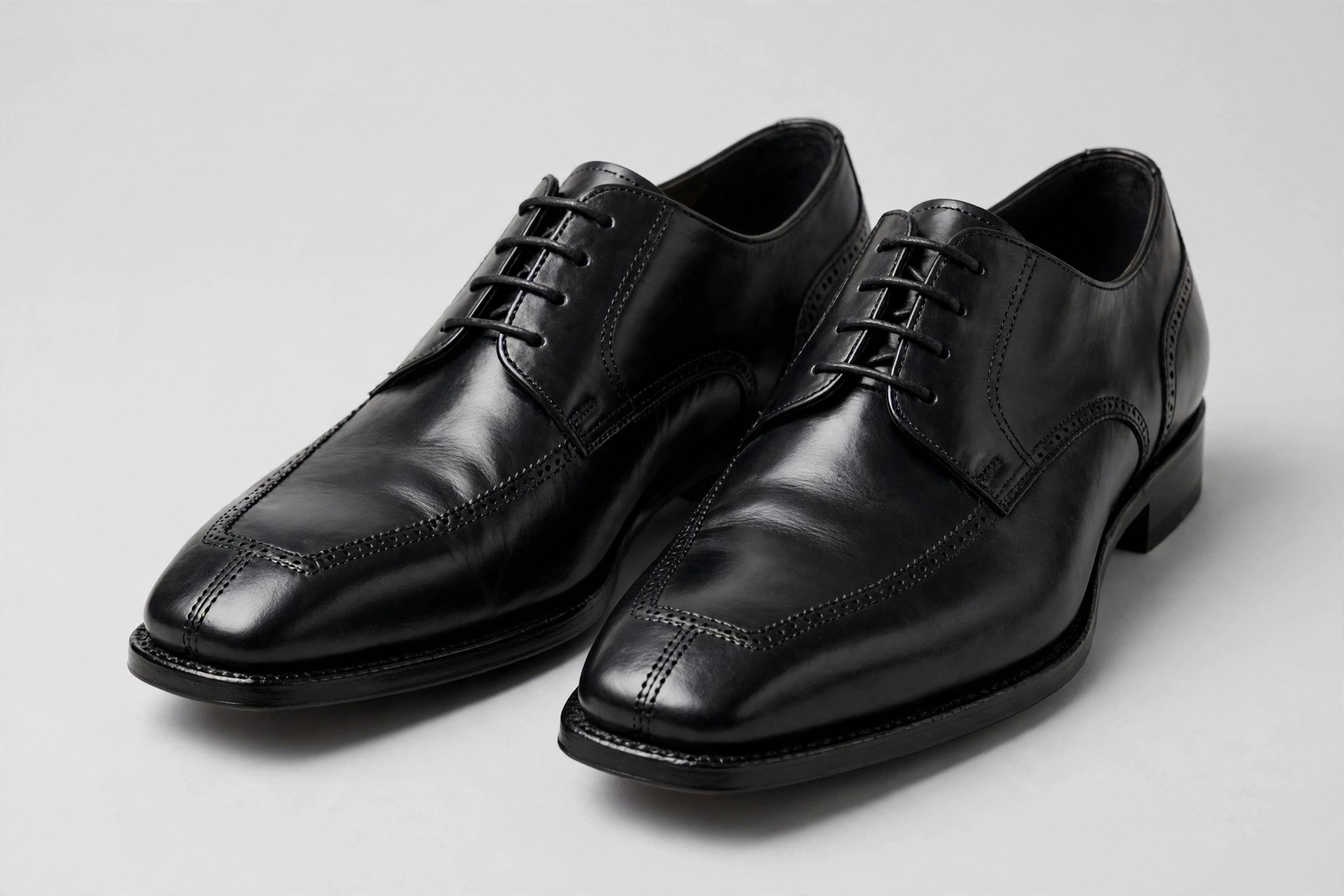 A pair of men's brown leather bicycle toe derby shoes with twin lengthwise seams over the squared toe, shown from above on a light floor
