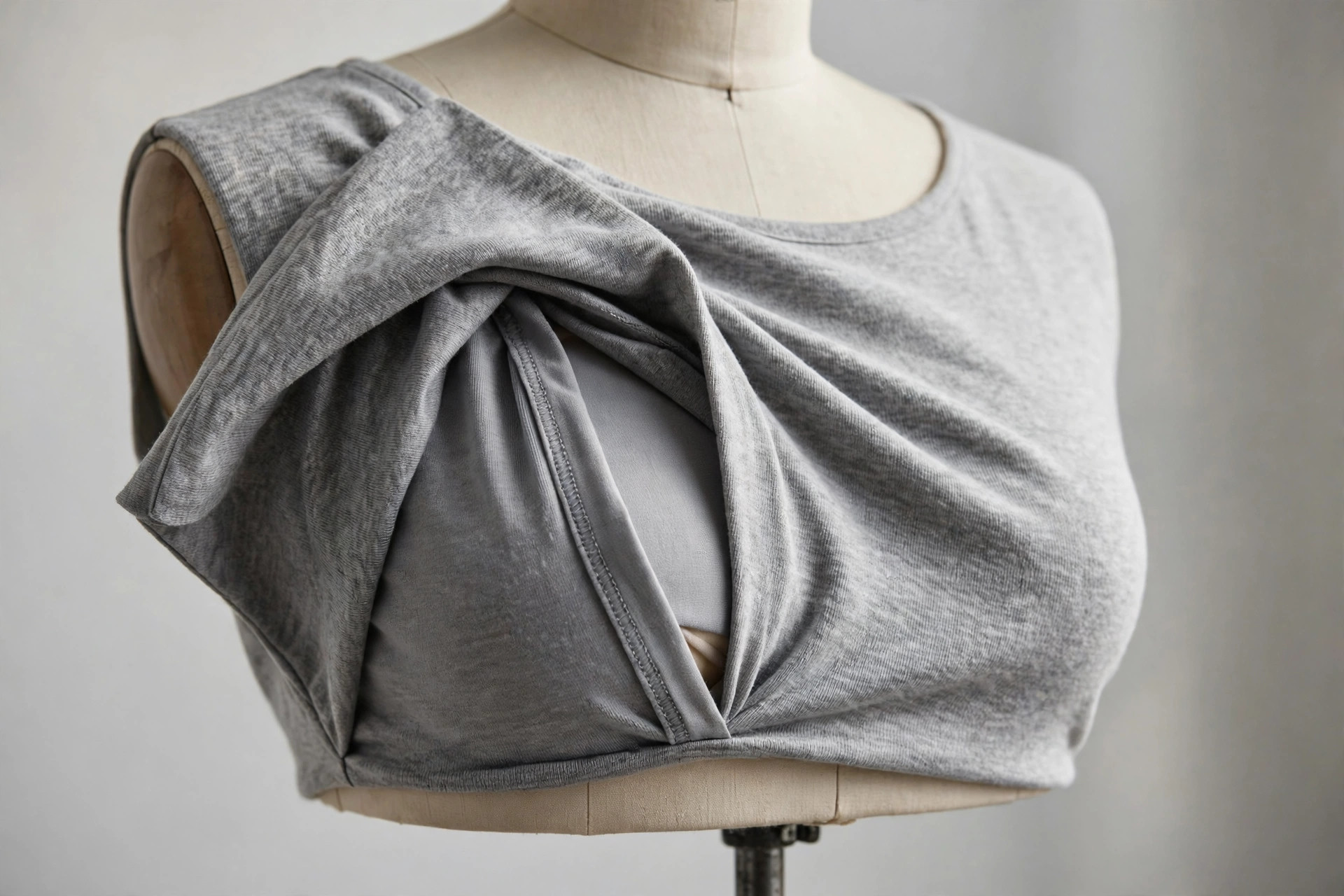 Close-up of a nursing top's double-layer front panel on a dress form mannequin, showing the hidden nursing opening