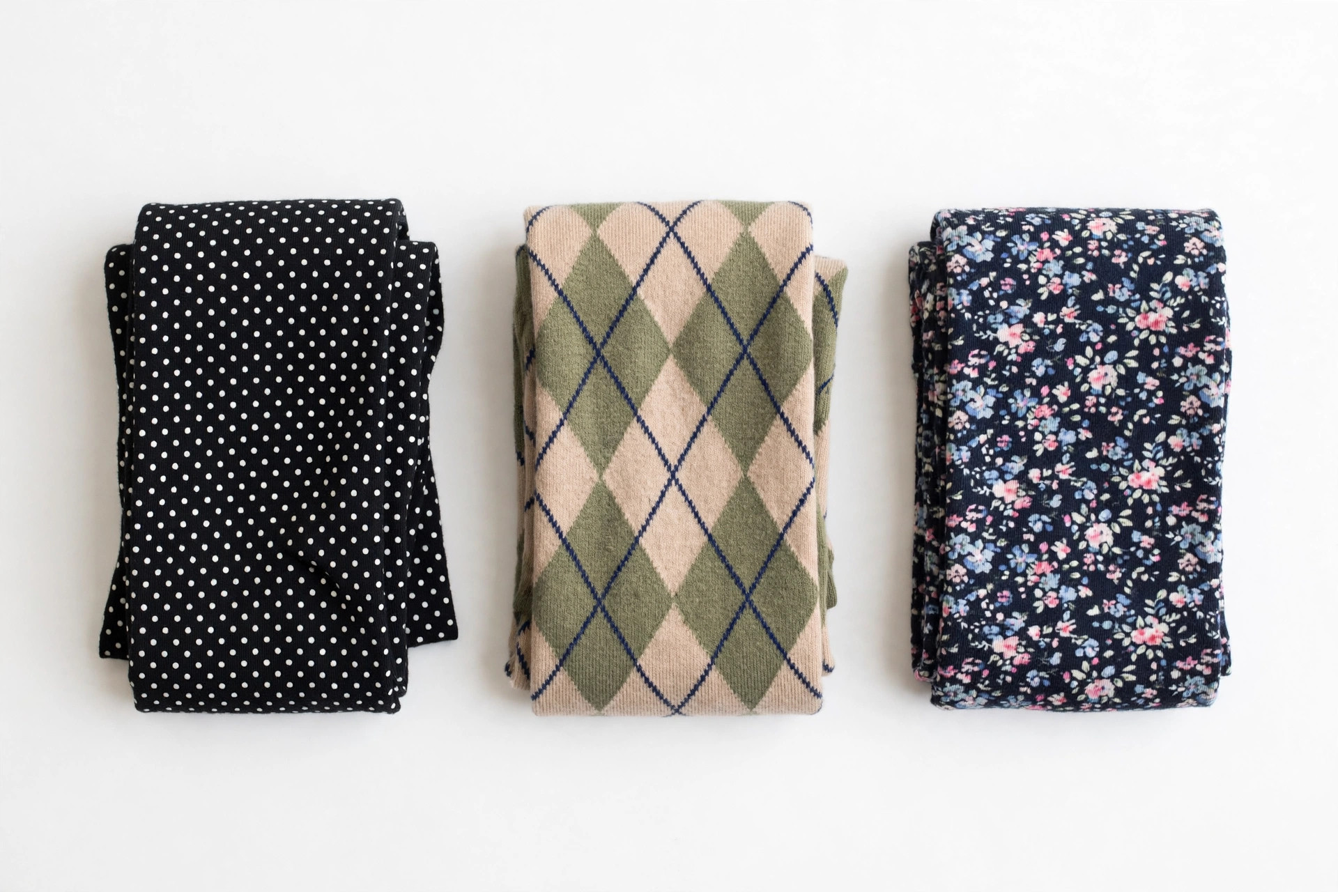 Flat lay of folded patterned tights in polka dot, diamond and floral designs