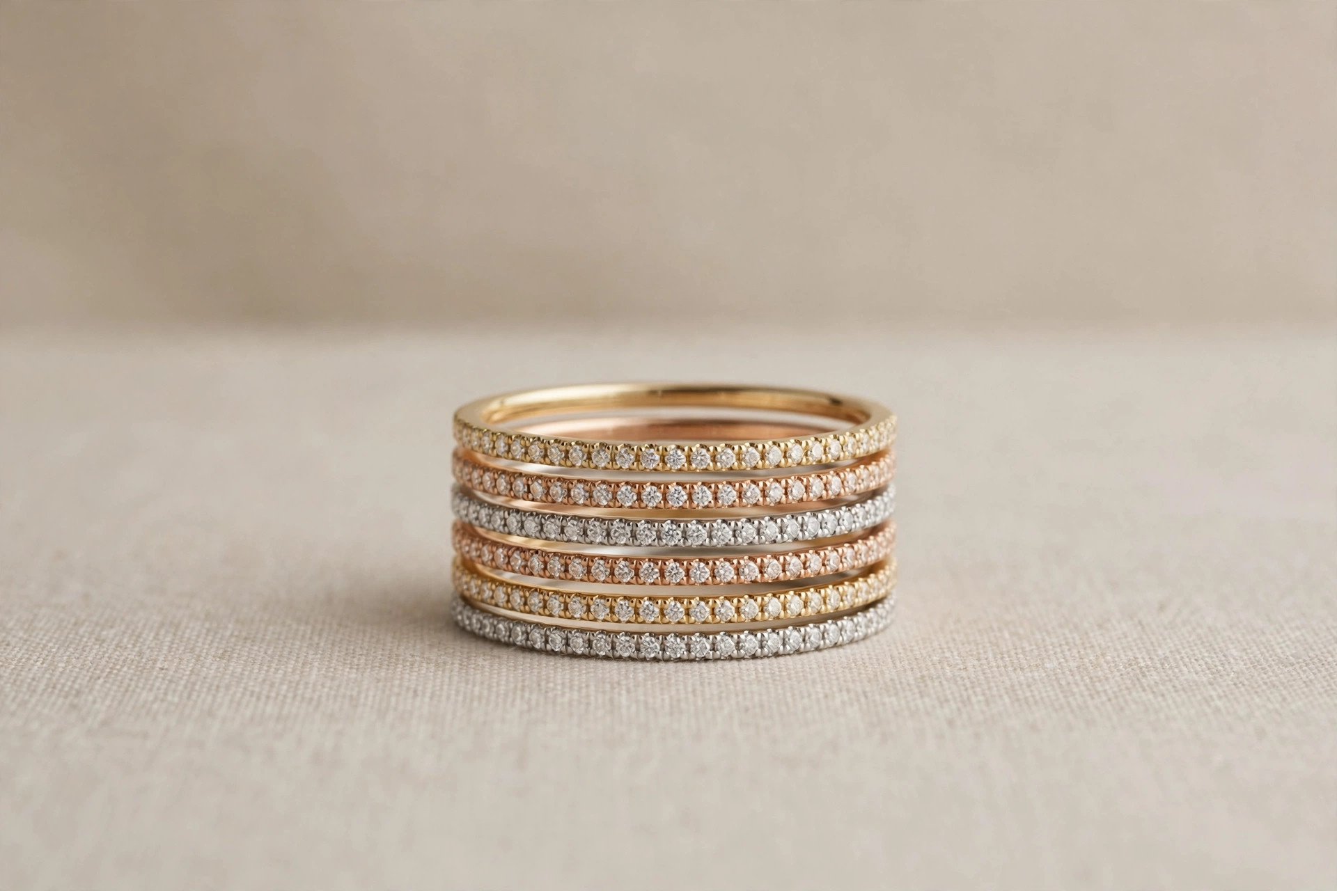 Set of thin stacking rings in mixed metals arranged in a stack on a neutral backdrop