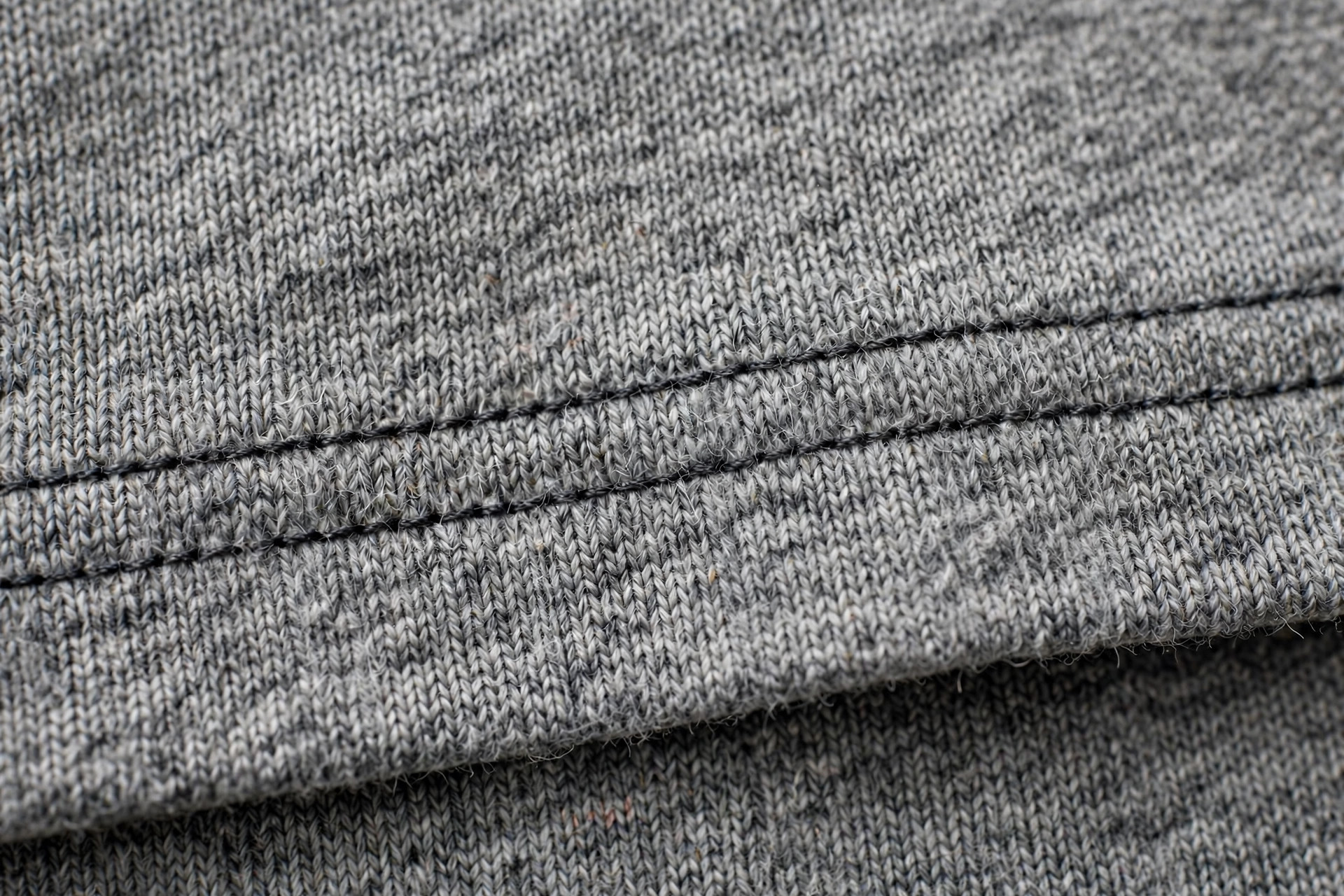 Close-up of a coverstitch hem on a knit t-shirt showing two parallel rows of stitching